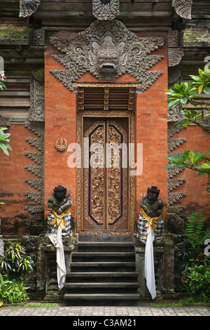 Ornate hand carved stone gate with Barong face of PURA DESA UBUD, the main Hindu temple of the town - UBUD, BALI Stock Photo