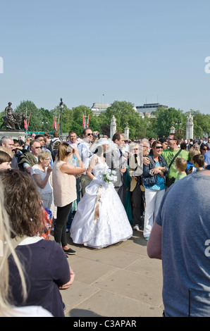 Woman in wedding dress with groom outside Buckingham Palace day after Royal wedding Prince William to Catherine Kate Middleton. Stock Photo