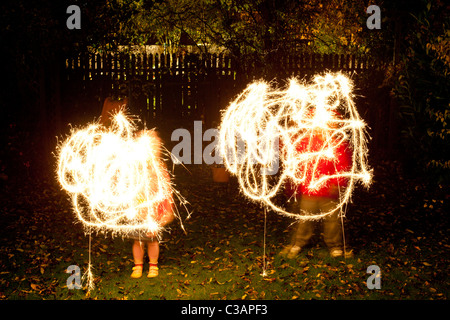 Children with sparklers in a garden Stock Photo