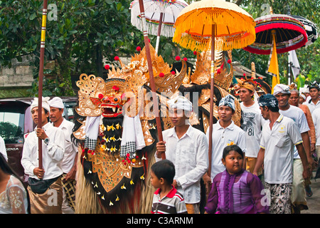 A BARONG COSTUME used in traditional LEGONG dancing is carried during a HINDU PROCESSION for a temple anniversary - UBUD, BALI Stock Photo