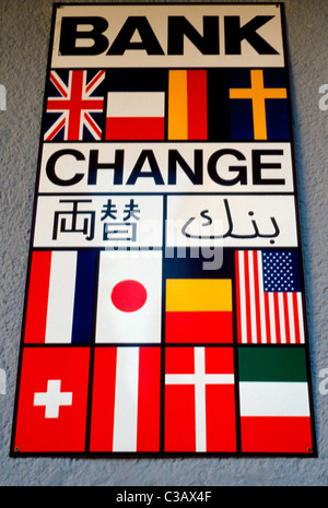 A sign with the flags of various countries indicates international money exchange is available inside a European bank in Austria. Stock Photo