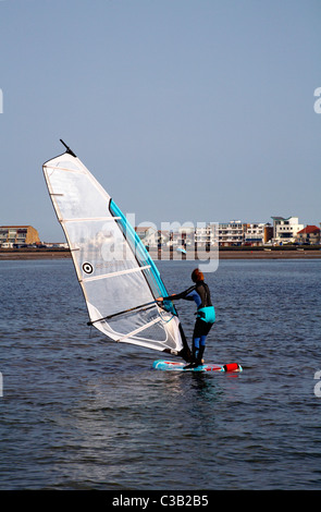 Female windsurfing at Sandbanks, Poole in April Stock Photo