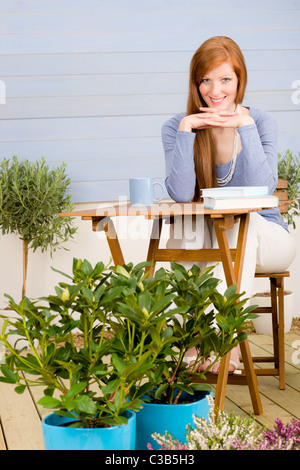 Summer terrace happy redhead woman relax in garden Stock Photo