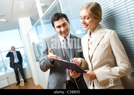 Portrait of executive specialists looking at document and discussing it Stock Photo