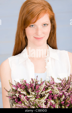 Summer close-up of redhead woman hold basket with flowers Stock Photo