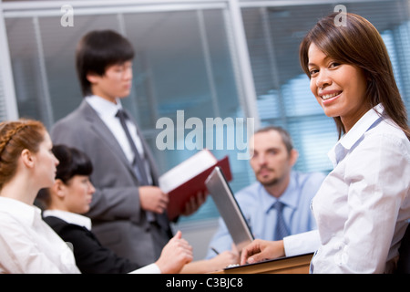 Portrait of smart employer looking at camera on background of people working Stock Photo