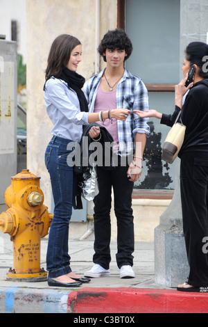 Joe Jonas of the Jonas Brothers and Camilla Belle walking down the