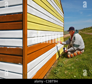 Man painting his beach hut. Stock Photo