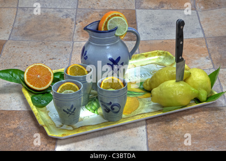 tray with lemons, oranges, apple and a jug and mugs Stock Photo - Alamy