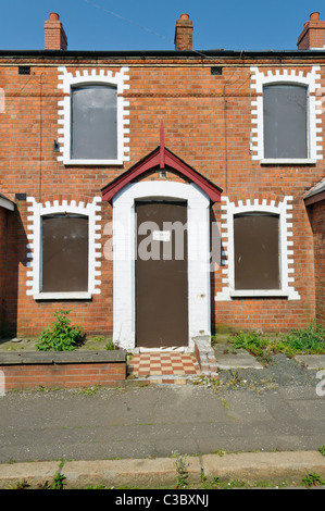 Entire street of abandoned and boarded up houses in a run-down area of a city Stock Photo