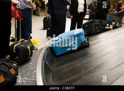Suitcase on the luggage baggage reclaim carousel belt at London Heathrow LHR International airport, terminal T 3 /  T three. UK. Stock Photo