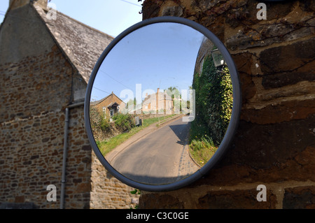 Convex mirror to aid motorists visibility in a village Stock Photo