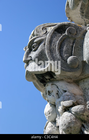 Detail of an ornamental stone urn, showing a grotesque face, England, UK Stock Photo