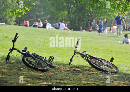 two bikes in hampstead heath people enjoying bank holiday sunshine families kids children mums dads Stock Photo