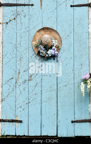 Closeup of picturesque Cape Cod barn door with decorated straw hat on door. USA Stock Photo