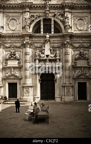 An artist painting and selling his work in one of the small piazzas in Venice, Italy Stock Photo