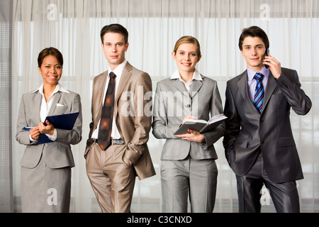 Elegant business people standing in line and looking at camera Stock Photo