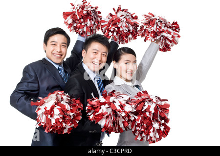 A team of businesspeople cheering with pompoms Stock Photo