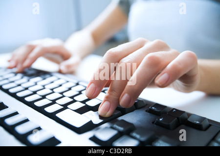 Close-up of female hand pressing enter key to start the system Stock Photo