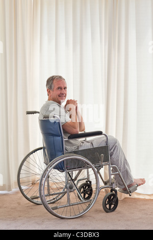 Smiling man in his wheelchair at home Stock Photo