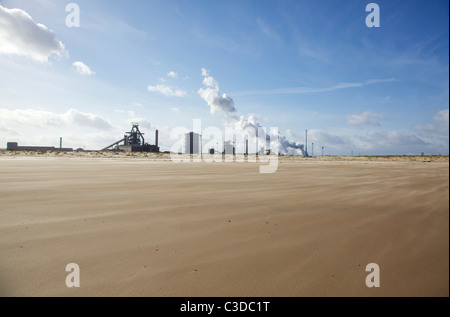 Redcar steelworks with wind blown sandy beach in foreground Stock Photo