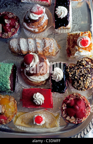 A silver tray is filled with a colorful selection of dessert pastries that tempt tourists vacationing at a 5-star hotel in Honolulu, Hawaii, USA. Stock Photo