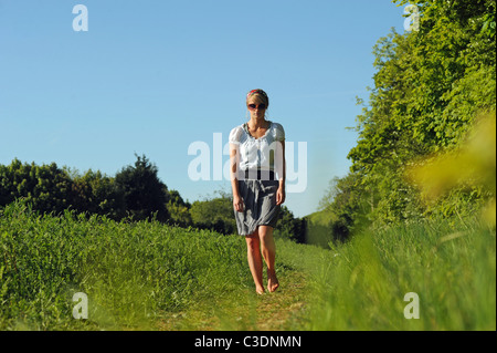 Blonde female wearing headscarf looking thoughtful outdoors in spring sunshine UK - posed by model Stock Photo