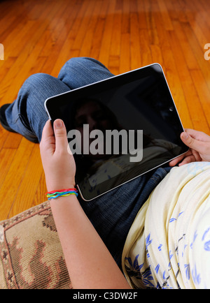 10 year old girl with blank Apple IPad in her lap. Stock Photo