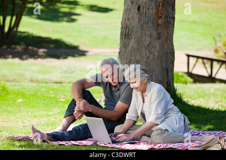 Senior couple using notebook in the garden Stock Photo