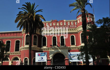 Blue sky view, with palm trees, of the red brick entrance of Arsenales de Guerra, damaged by 2010 earthquake, Santiago, Chile Stock Photo