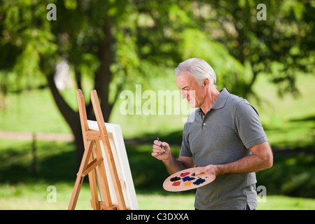 Senior man painting in the garden Stock Photo
