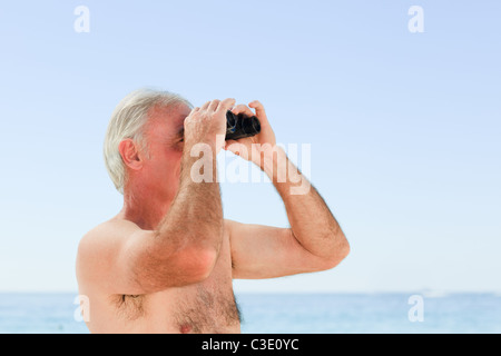 Senior man bird watching at the beach Stock Photo
