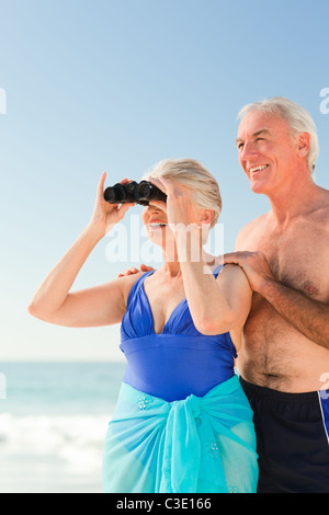 Elderly couple bird watching at the beach Stock Photo
