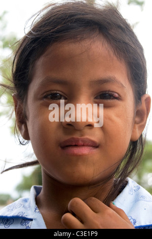 A young girl living in poverty poses for a portrait at her wood home in ...