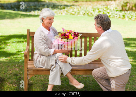 Senior man offering flowers to his wife Stock Photo