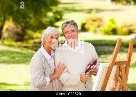 Retired couple painting in the park Stock Photo