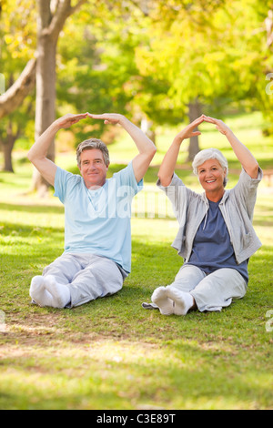 Elderly couple doing their stretches in the park Stock Photo
