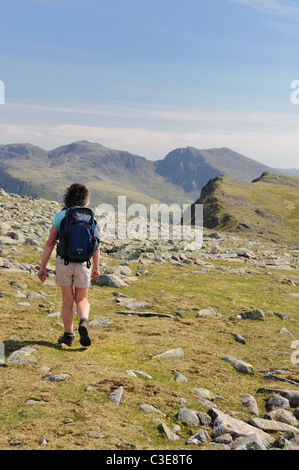 Female walker on Red Pike in the English Lake District, with Scafell and Scafell Pike in the background Stock Photo