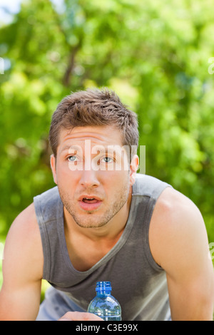 Sporty man drinking water in the park Stock Photo