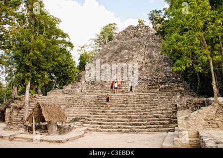 COBA MAYA RUINS, Mexico - La Iglesia (The Church), one of the larger structures at Coba. The small structure with the thatched roof in the foreground has been designated as Stela 11 at Coba, an expansive Mayan site on Mexico's Yucatan Peninsula not far from the more famous Tulum ruins. Nestled between two lakes, Coba is estimated to have been home to at least 50,000 residents at its pre-Colombian peak. Stock Photo