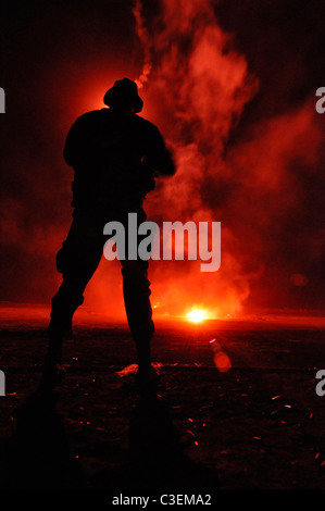 US Navy SEAL team member is illuminated by a flare during a night training exercise on San Clemente Island. Stock Photo