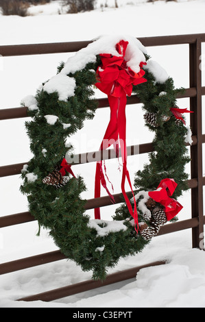 A Christmas wreath and bow are placed on a ranch gate in the Potomac Valley of western Montana. Stock Photo