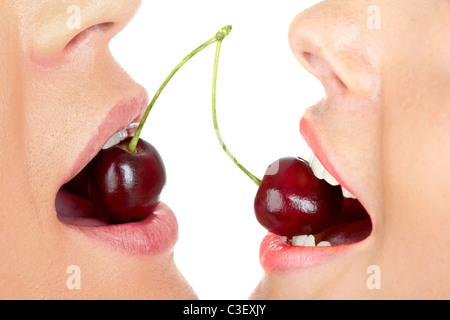 Close-up of man and woman holding cherries in their mouths Stock Photo