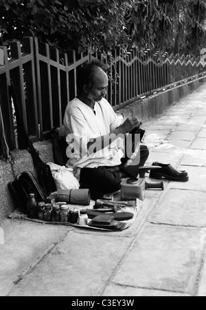 Shoemaker on footpath, New Delhi, India Stock Photo