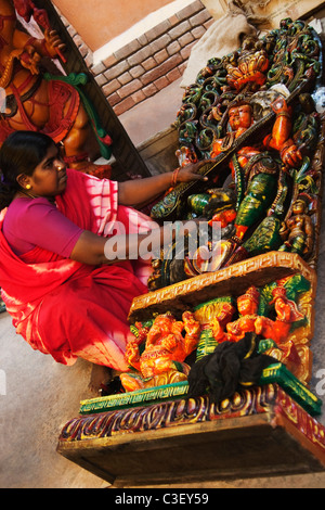 Woman with statue of Goddess Saraswati at a market stall, New Delhi, India Stock Photo