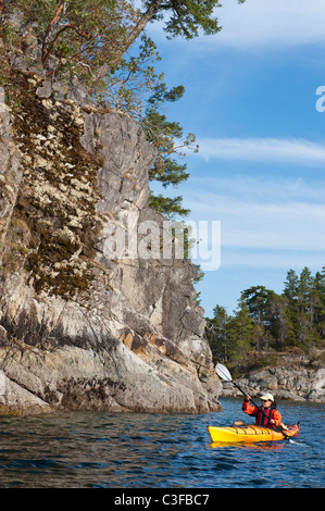 Hispanic woman kayaking on lake Stock Photo