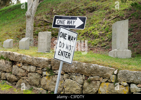 Conceptual shot of one way do not enter signs by gravestones, USA. Stock Photo
