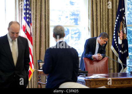 President Barack Obama makes phone calls from the Oval Office with Chief of Staff Rahm Emanuel and Assistant to the President Stock Photo