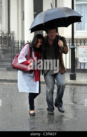 Freida Pinto and Josh Brolin filming a scene in artificial rain on the set of the 'Untitled Woody Allen London Project' London, Stock Photo