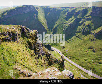 A driver negotiates the steep limestone gorge of Winnat's Pass near Castleton in the Derbyshire Peak District Stock Photo